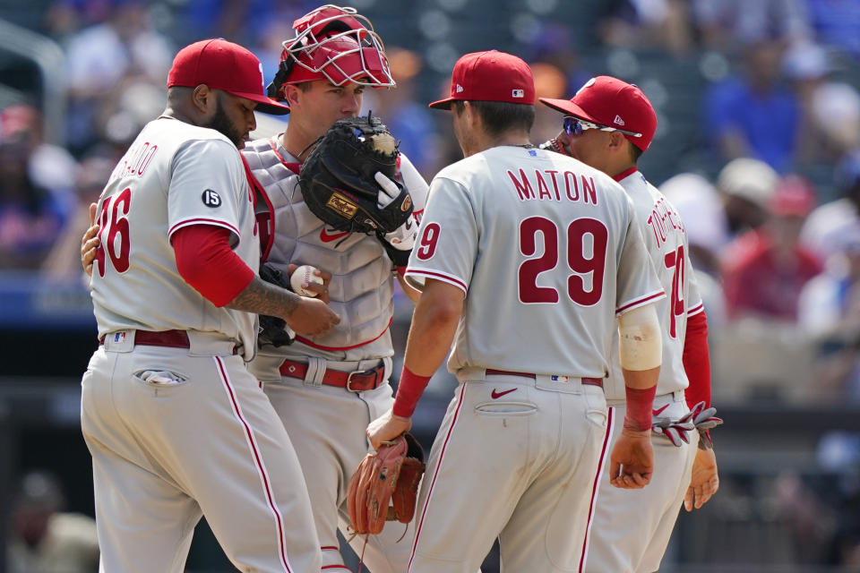 Philadelphia Phillies catcher J.T. Realmuto, second from left, talks to relief pitcher Jose Alvarado, left, as second baseman Nick Maton (29) and shortstop Ronald Torreyes (74) gather around for a mound conference of during the eighth inning of a baseball game against the New York Mets, Sunday, June 27, 2021, in New York. (AP Photo/Kathy Willens)