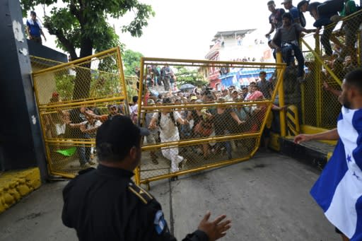 Honduran migrants tear down the gate of the Guatemala-Mexico international border bridge in Ciudad Hidalgo, Mexico