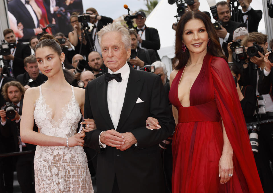 Carys Zeta Douglas, de izquierda a derecha, Michael Douglas y Catherine Zeta-Jones posan a su llegada a la ceremonia de apertura y al estreno de la película "Jeanne du Barry" en la 76a edición del festival internacional de cine de Cannes, en el sur de Francia, el martes 16 de mayo de 2023. (Foto Joel C Ryan/Invision/AP)