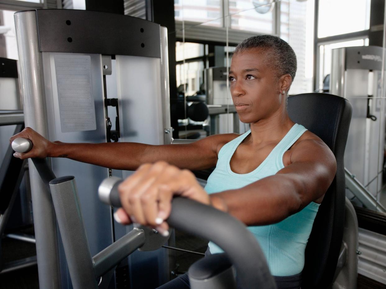 a woman working out on an exercise machine in a gym