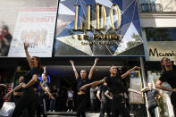 Lido cabaret dancers perform on the Champs-Elyses avenue during a demonstration to try to save their jobs and the history of the cabaret, known for its dinner theater and its "Bluebell Girls" revue, Saturday, May 28, 2022 in Paris. Amid financial troubles and changing times, the venue's new corporate owner is ditching most of the Lido's staff and its high-kicking, high-glamour dance shows — which date back decades and inspired copycats from Las Vegas to Beirut — in favor of more modest musical revues. (AP Photo/Thomas Padilla)