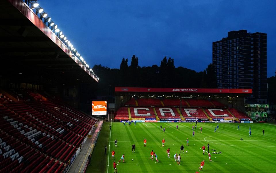 A general view of Charlton Athletic players warming up in front of empty stands before the EFL Trophy match at The Valley, London. - PA