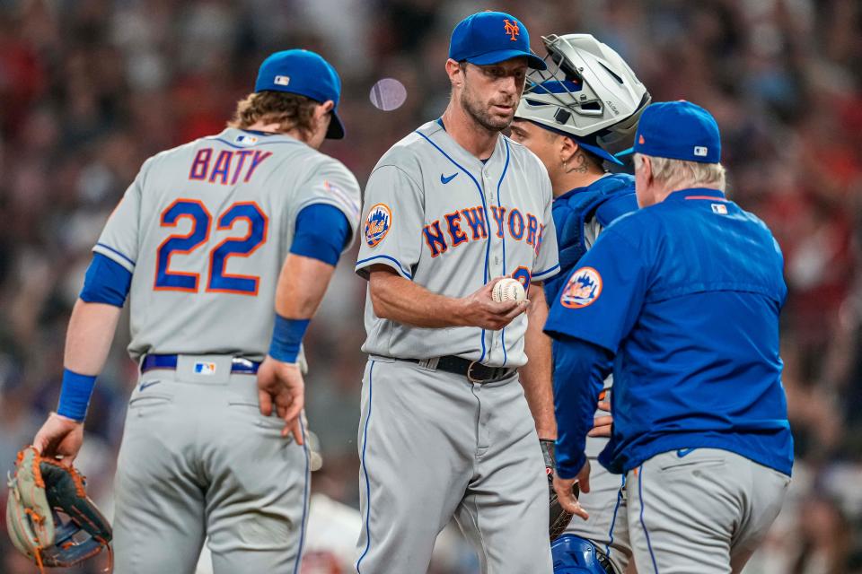 New York Mets starting pitcher Max Scherzer (21) hands the ball to manager Buck Showalter (11) after being removed from the game against the Atlanta Braves during the sixth inning on June 7, 2023, at Truist Park.