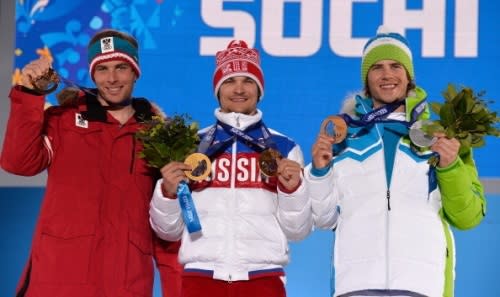 Bronze medalist Benjamin Karl of Austria, gold medalist Vic Wild of Russia and silver medalist Zan Kosir of Sloveniacelebrate for the Snowboard Men's Parallel Slalom