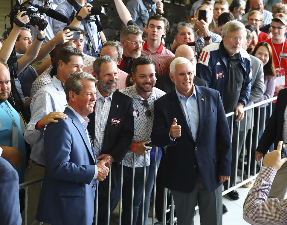 Former Vice President Mike Pence, headlining a Get Out the Vote Rally with Governor Brian Kemp, works the crowd with Kemp at the end of the event on the eve of Georgia's primary at the Cobb County International Airport on Monday, May 23, 2022, in Kennesaw, Ga. (Curtis Compton/Atlanta Journal-Constitution via AP)