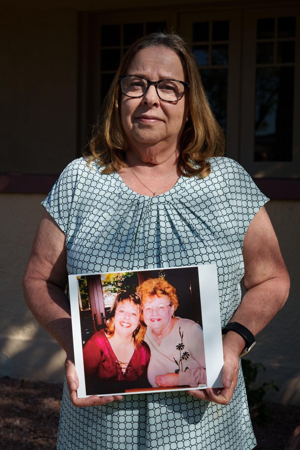 Peggy Brown poses with a photo of her and mother, Joyce Dinet, on March 17, 2023 in Phoenix.