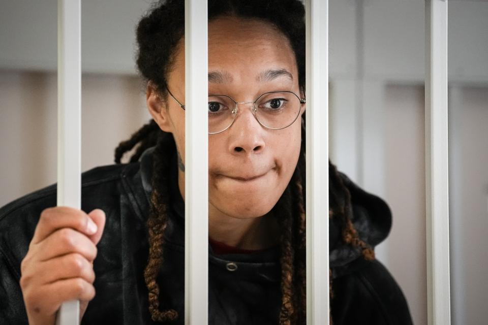 FILE - WNBA star and two-time Olympic gold medalist Brittney Griner speaks to her lawyers standing in a cage at a court room prior to a hearing, in Khimki just outside Moscow, Russia, on July 26, 2022. Russia has freed WNBA star Brittney Griner on Thursday in a dramatic high-level prisoner exchange, with the U.S. releasing notorious Russian arms dealer Viktor Bout. (AP Photo/Alexander Zemlianichenko, Pool, File)