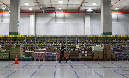 An employee passes shelves of merchandise at Amazon's Prime Now fulfillment centre in Singapore July 27, 2017. REUTERS/Edgar Su