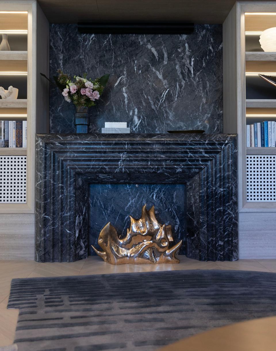 A mirror-polished bronze sculpture by FP Art decorates the marble faux fireplace in the living room of the suite.