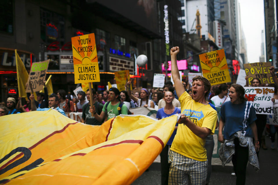 People shouts slogans while they march through Times Square in New York City on Sept. 21, 2014 to call for solutions to climate change.