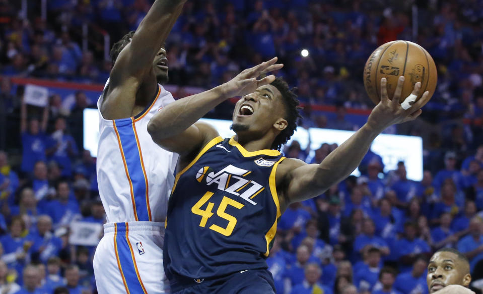 Utah Jazz guard Donovan Mitchell (45) shoots as Oklahoma City Thunder forward Jerami Grant, left, defends in the second half of Game 1 of an NBA basketball first-round playoff series in Oklahoma City, Sunday, April 15, 2018. (AP Photo/Sue Ogrocki)