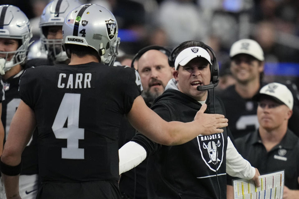 Las Vegas Raiders quarterback Derek Carr is congratulated by offensive coordinator Mike Lombardi after a touchdown pass during the first half of an NFL football game between the New England Patriots and Las Vegas Raiders, Sunday, Dec. 18, 2022, in Las Vegas. (AP Photo/John Locher)
