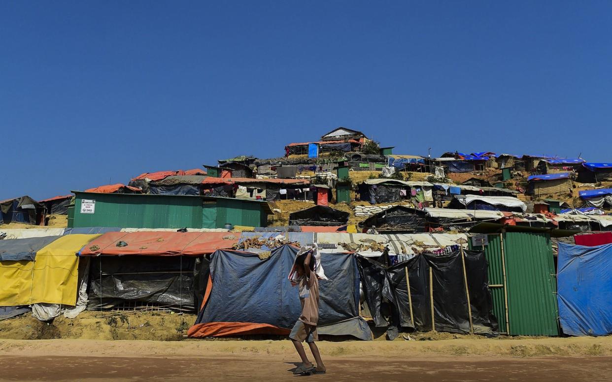 A young Rohingya refugee walks back home with relief material at Thankhali refugee camp in Bangladesh's Ukhia district on Sunday - AFP