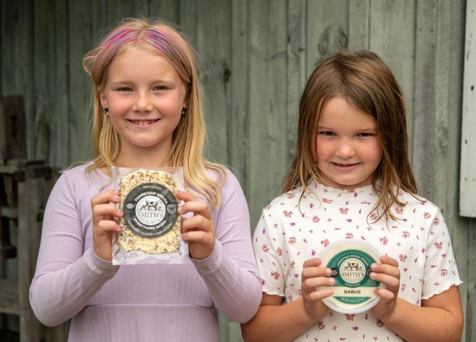 Sisters Samantha, 8, and Sadie, 6, hold their favorite variety of cheese at their parents’ Smith’s Country Cheese Thursday.