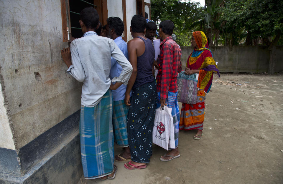 In this Aug. 31, 2019 photo, villagers wait to check their names in the final list of National Register of Citizens in Morigaon district, Assam, India. About 1.9 million people were left out of the National Register of Citizens _ a mammoth exercise to weed out illegal mainly Bangladeshi immigrants from Assam’s more than 32 million people. (AP Photo/Anupam Nath)