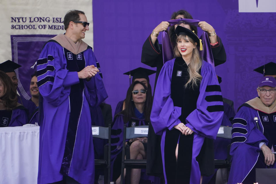 Taylor Swift, right, receives an honorary degree during a graduation ceremony for New York University at Yankee Stadium in New York, Wednesday, May 18, 2022. (AP Photo/Seth Wenig)