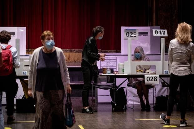 Voters at a University-Rosedale polling station on Monday. Some people reported it had been a busy, and at times frustrating day for voters in the city.  (Evan Mitsui/CBC - image credit)