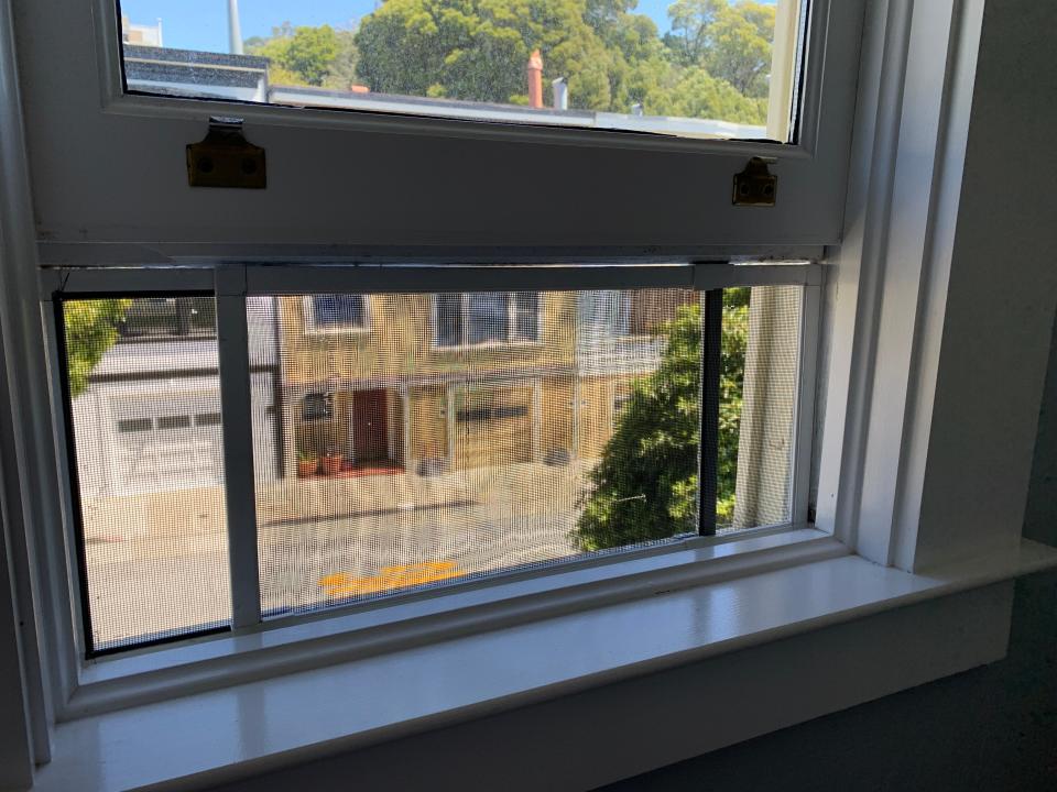 An adjustable window screen in use.