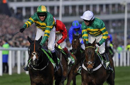 Jockey Barry Geraghty on Jezki (L) wins the Champion Hurdle Challenge Trophy ahead of jockey Tony McCoy on My Tent Or Yours (R) at the Cheltenham Festival horse racing meet in Gloucestershire, western England March 11, 2014. REUTERS/Toby Melville