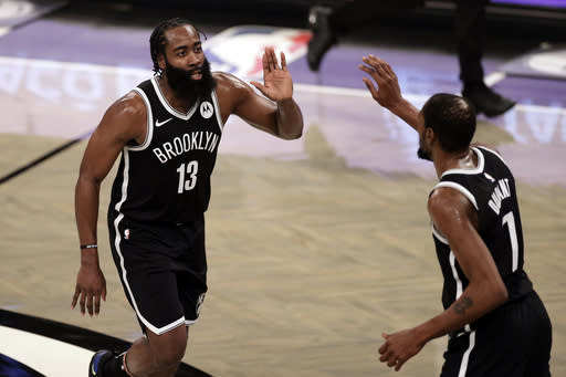 Brooklyn Nets guard James Harden celebrates with forward Kevin Durant (7) during the second half of an NBA basketball game against the Milwaukee Bucks, Monday, Jan. 18, 2021, in New York. (AP Photo/Adam Hunger)