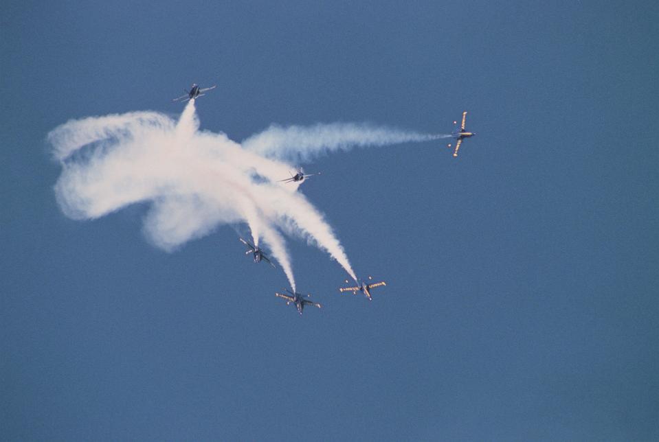 Trailing white smoke, six F/A-18 Hornet aircraft of the Blue Angels flight demonstration team execute an aerial fleur de lis.