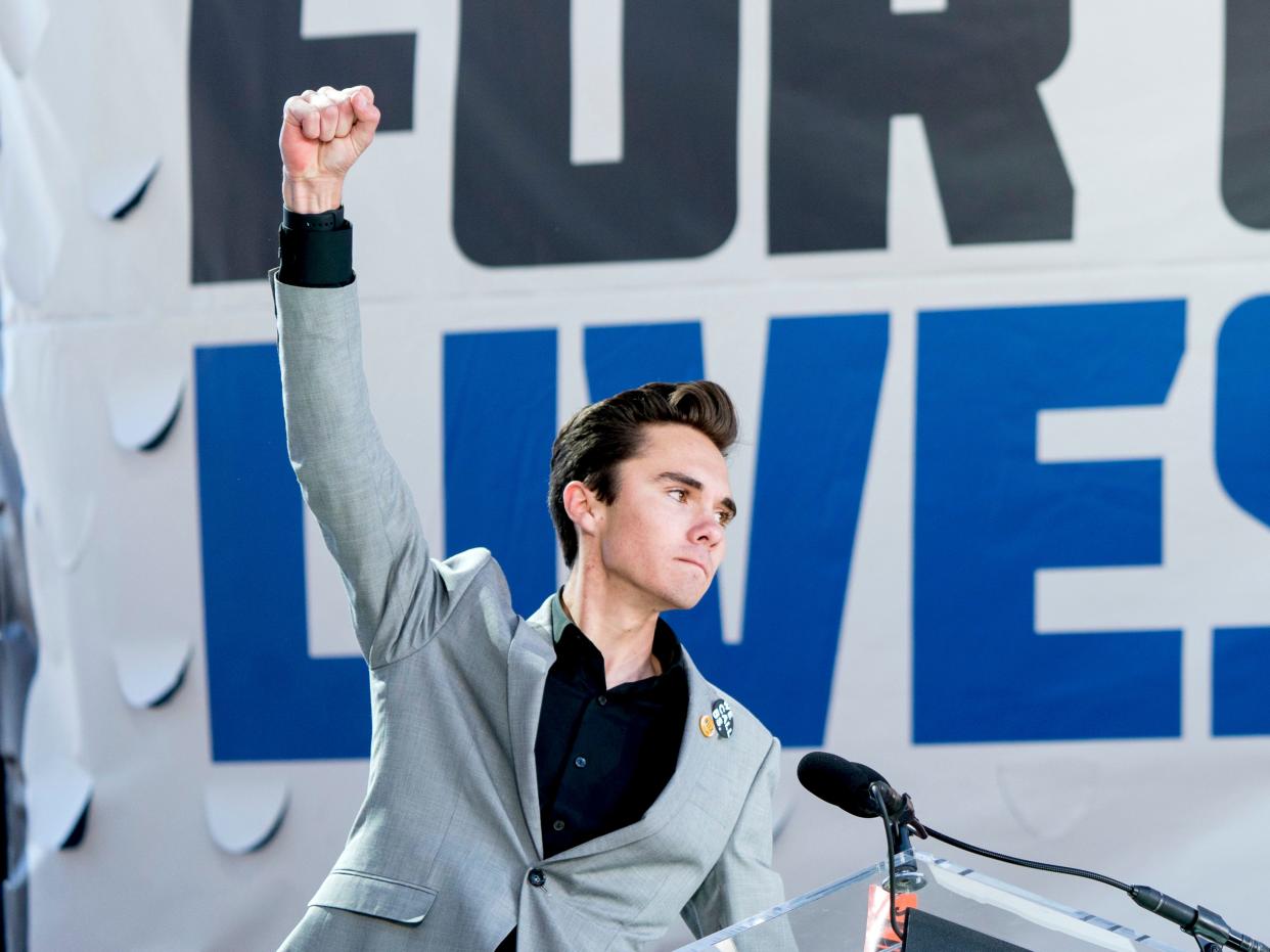 In this March 24, 2018, file photo, David Hogg, a survivor of the mass shooting at Marjory Stoneman Douglas High School in Parkland, Fla., raises his fist after speaking during the March for Our Lives rally in support of gun control in Washington. 