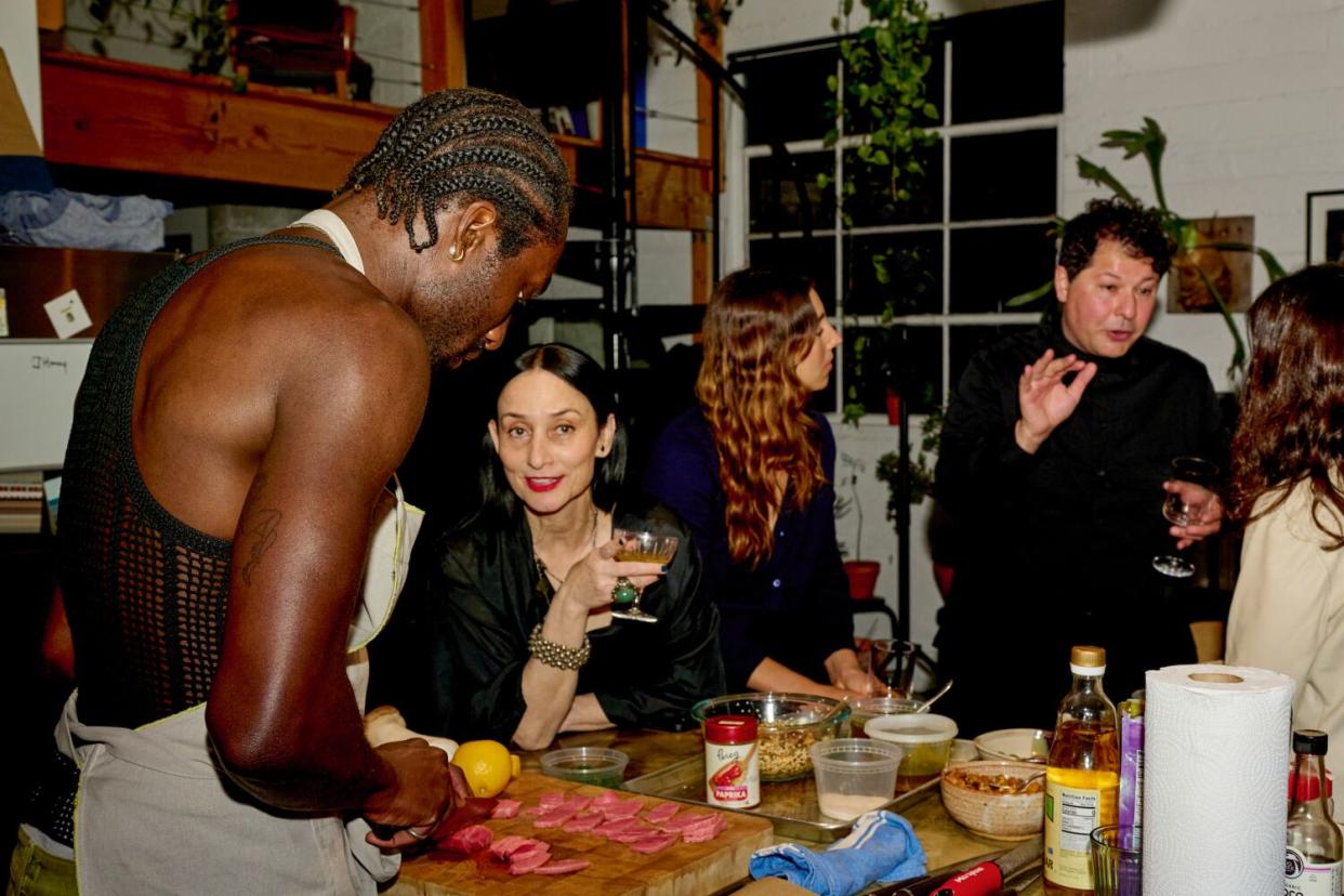 DeVonn Francis makes an appetizer for a dinner party as guest Rose Apodaca looks on.
