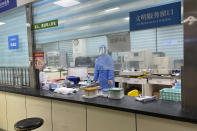 A hospital worker stands behind a counter at the Baigou New Area Aerospace Hospital in Baigou, northern China's Hebei province on Thursday, Dec. 22, 2022. As China grapples with its first-ever wave of COVID mass infections, emergency wards in the towns and cities to Beijing's southwest are overwhelmed. Intensive care units are turning away ambulances, residents are driving sick relatives from hospital to hospital, and patients are lying on floors for a lack of space. (AP Photo)