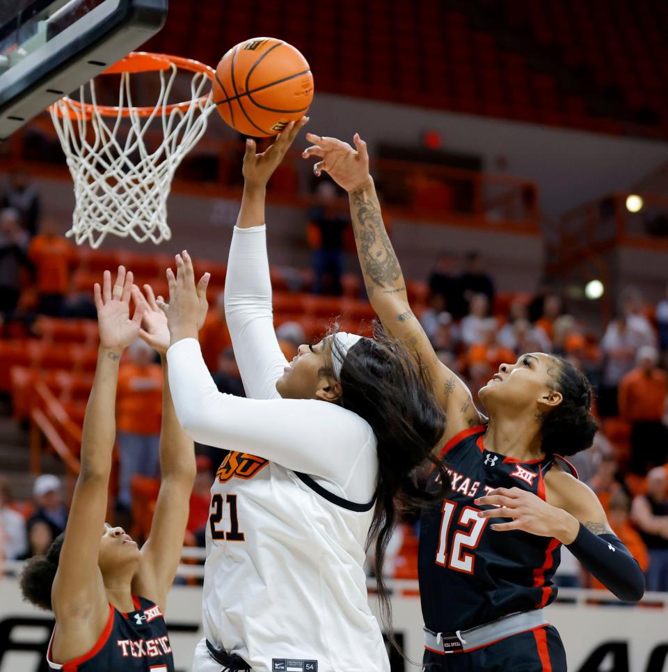 Oklahoma State Cowgirls center Hannah Gusters (21) puts up a shot between Texas Tech Lady Raiders guard Kilah Freelon (2) and guard Jordyn Merritt (12) during a women's college basketball game between the Oklahoma State Cowgirls (OSU) and the Texas Tech Lady Raiders at Gallagher-Iba Arena in Stillwater, Okla., Wednesday, Jan. 10, 2024. Oklahoma State won 71-58.