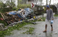 <p>A man looks at a damaged house due to strong winds from Typhoon Mangkhut as it barreled across Tuguegarao city in Cagayan province, northeastern Philippines on Saturday, Sept. 15, 2018.<br>The typhoon slammed into the Philippines northeastern coast early Saturday, it’s ferocious winds and blinding rain ripping off tin roof sheets and knocking out power, and plowed through the agricultural region at the start of the onslaught.<br>(Photo by Aaron Favila, AP) </p>