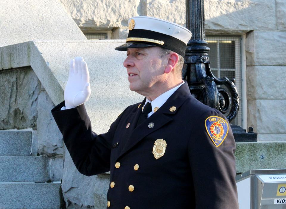 Harp Donnelly IV raises his right hand as he's sworn in as Newport's fire chief on the steps of City Hall on Friday.