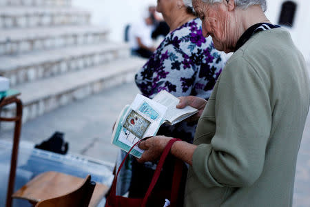 A local woman holds her medical booklet as she waits to be examined by volunteer doctors of the Aegean Team on the islet of Thymaina, Greece, May 11, 2017. REUTERS/Alkis Konstantinidis