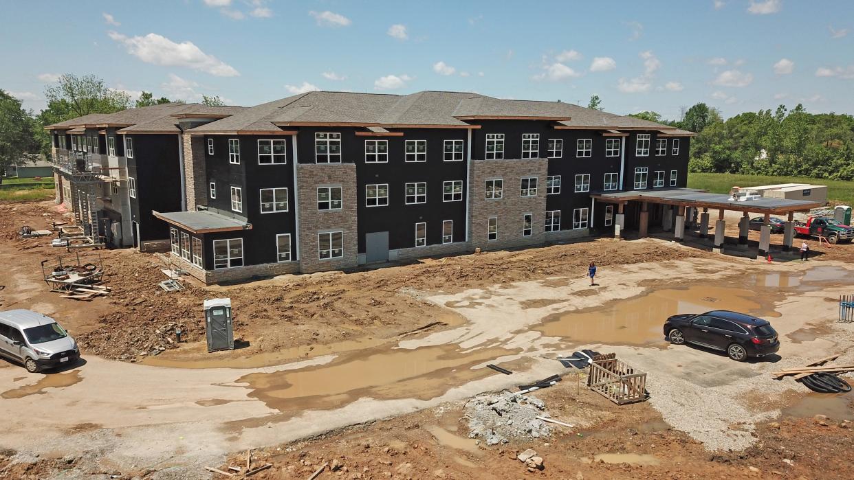 A woman navigates the mud May 16 at the Touchstone Field Place apartments, 2565 Lockbourne Rd., after a news conference about affordable housing featuring U.S. Housing and Urban Development Secretary Marcia Fudge, Columbus Mayor Andrew  J. Ginther and U.S.  Joyce Beatty, D-Columbus.