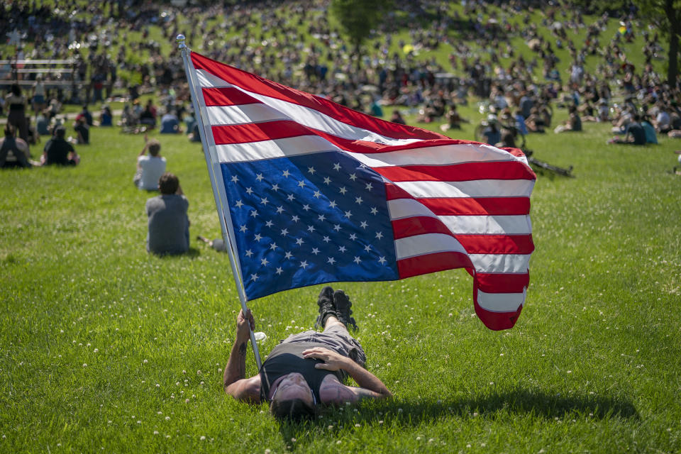 CORRECTS MONTH TO JUNE NOT MAY - Rory Wakemup holds an upside-down United States flag at "The Path Forward" meeting, a meeting between city council and community members, at Powderhorn Park, Sunday, June 7, 2020, in Minneapolis. The focus of the meeting was to defund the Minneapolis Police Department. ( Jerry Holt/Star Tribune via AP)