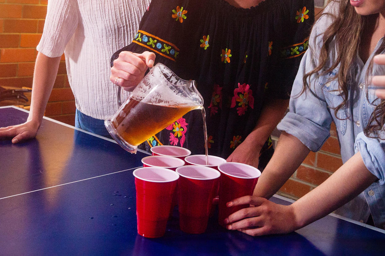 Woman holding pitcher with beer and pouring drinking at a party Getty Images/stellalevi