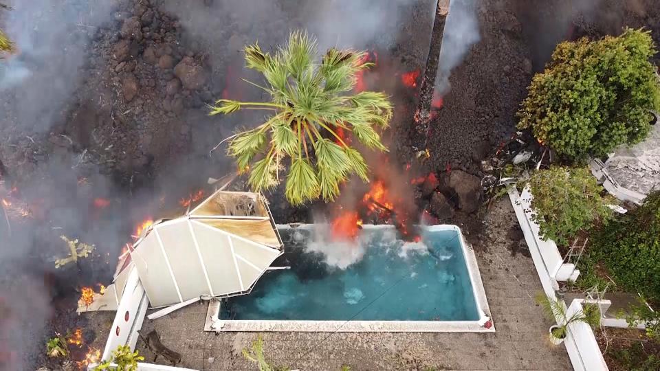 Hot lava reaches a swimming pool after an eruption of a volcano on the island of La Palma in the Canaries, Spain, Monday, Sept. 20, 2021. Giant rivers of lava are tumbling slowly but relentlessly toward the sea after a volcano erupted on a Spanish island off northwest Africa. The lava is destroying everything in its path but prompt evacuations helped avoid casualties after Sunday's eruption.