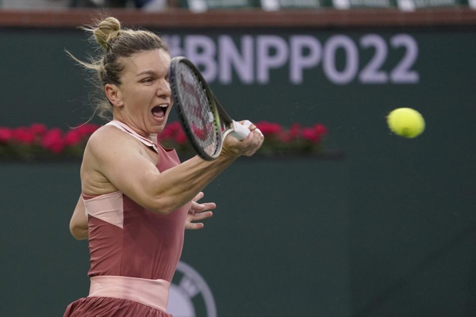 Simona Halep returns a shot during her loss to Iga Swiatek on Friday.