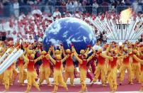 <p>A chorus of Ode to Joy by singers from five continents symbolizes hope for world peace. Anti-land mine activist Chris Moon leads the torch into Olympic Stadium. </p>