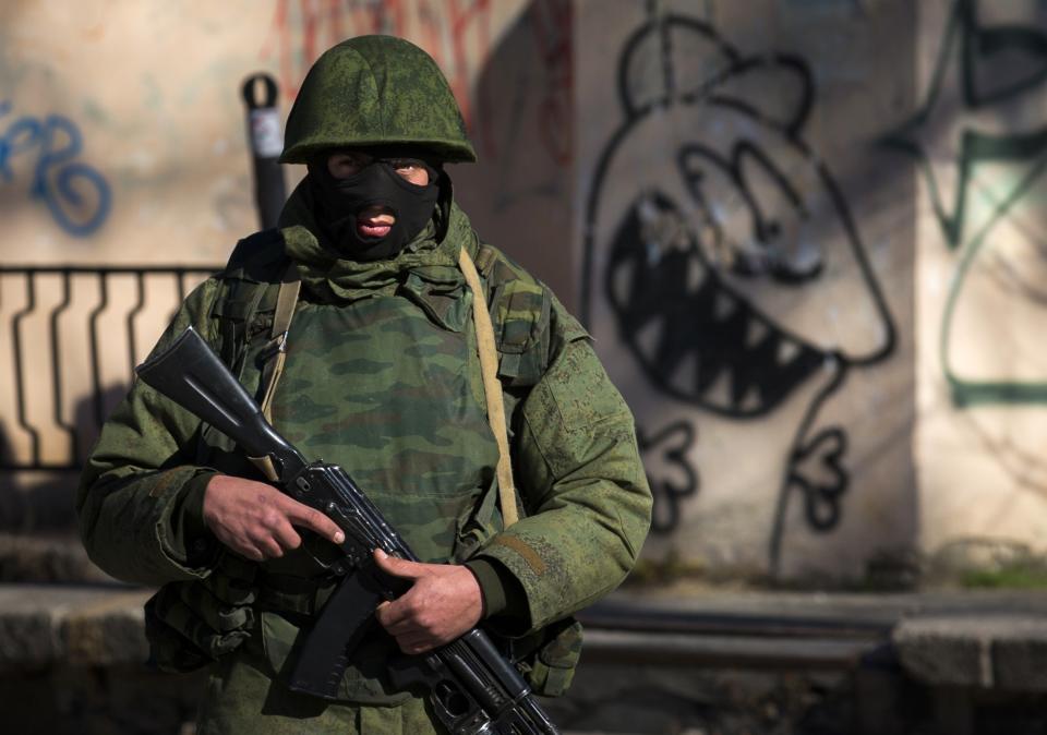 An armed man stands near a Ukrainian military base in Simferopol