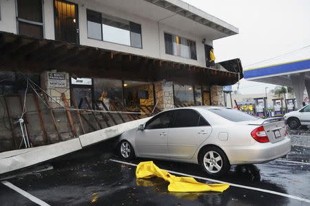 A second-story walkway to apartment units is shown after it collapsed during heavy rains in Long Beach, California, December 12, 2014. REUTERS/Bob Riha Jr.