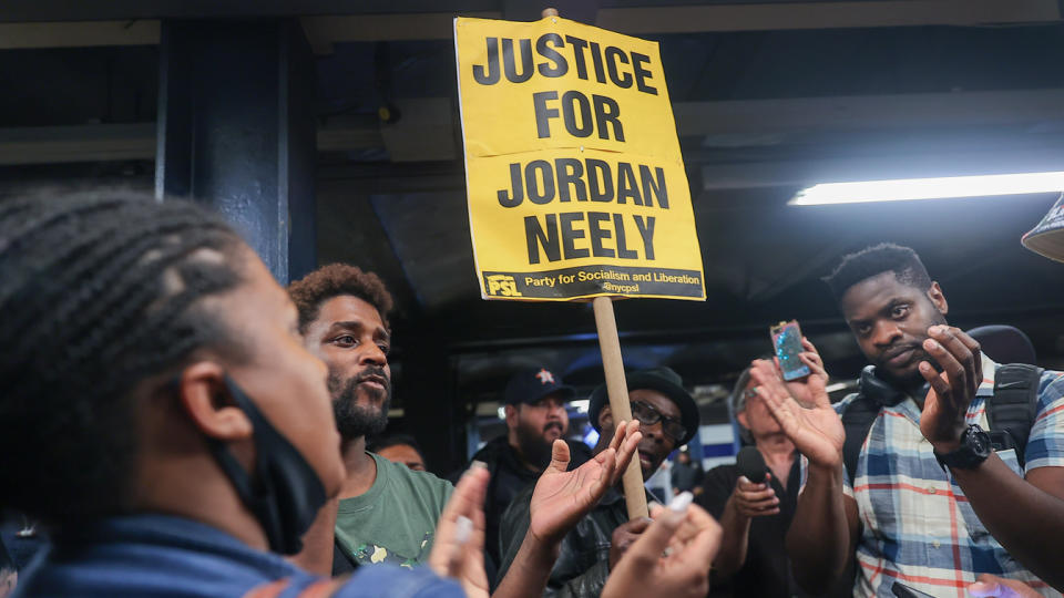 A vigil on Monday to honor Jordan Neely's life. One person holds a sign reading: Justice for Jordan Neely.