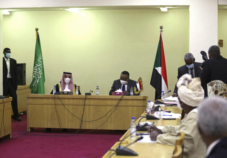 CORRECTION: CORRECTS TITLE AND NAME TO SUDANESE ACTING FOREIGN MINISTER OMAR QAMAR AL-DIN - Sudanese acting Foreign Minister Omar Qamar al-Din, center right, welcomes Saudi Foreign Minister Prince Faisal bin Farhan, center left, upon his arrival to Khartoum Airport. in Khartoum, Sudan, Tuesday, Dec. 8, 2020. The prince's visit is the first by the Kingdom's top diplomat since Sudan's military overthrew former autocratic leader President Omar al-Bashir last year. (AP Photo / Marwan Ali)