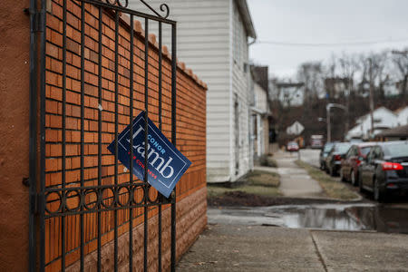 A sign showing support for Congressional candidate Conor Lamb hangs from, a gate in the town of Carnegie, Pennsylvania, U.S., February 16, 2018. Picture taken February 16, 2018. REUTERS/Maranie Staab