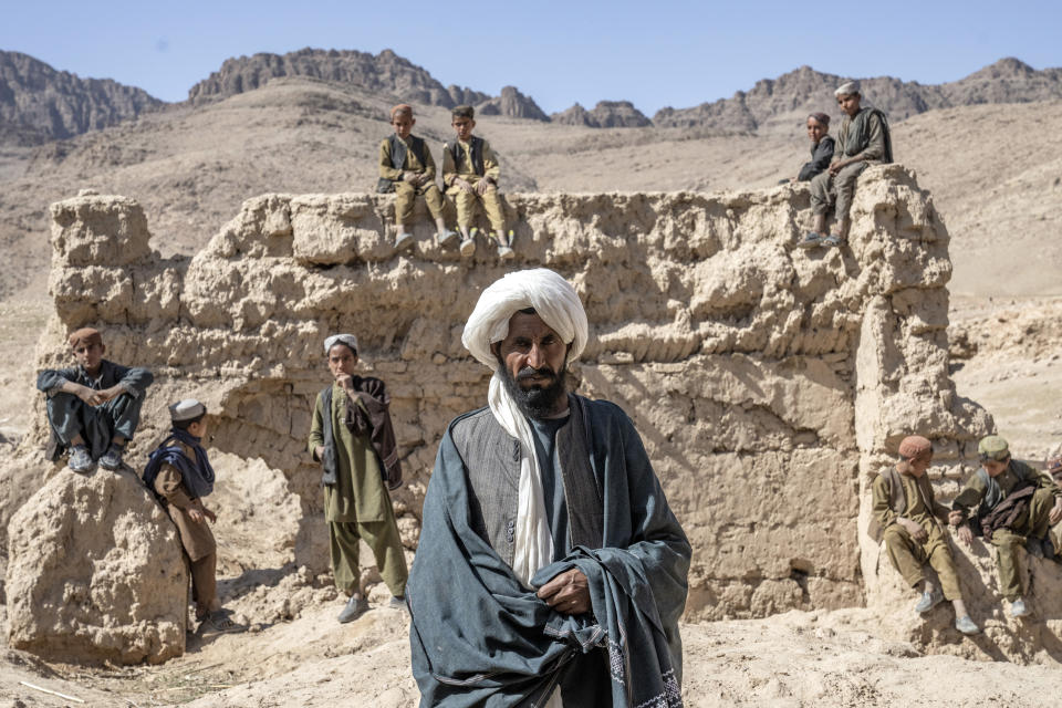 Abdul Khaliq stands near a destroyed home in a remote village in Afghanistan on Friday, Feb. 24, 2023. He says his friends who lived in the home were killed there during a 2019 night raid. After the attack, he said the stench from the bodies was overwhelming; villagers scooped up the surviving children and drove the injured to a government hospital. (AP Photo/Ebrahim Noroozi)