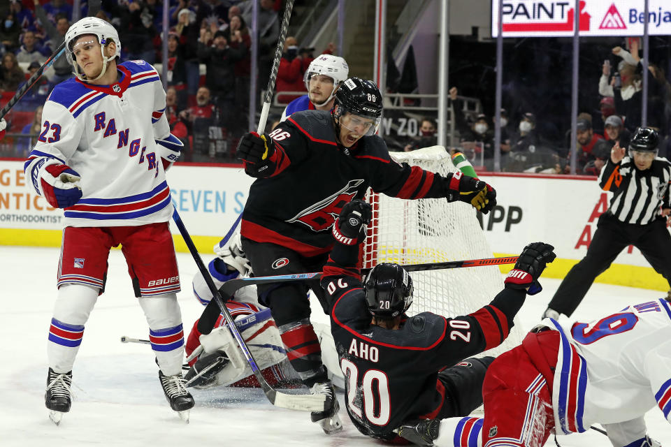 Carolina Hurricanes' Teuvo Teravainen (86) congratulates teammate Sebastian Aho (20) on his goal with New York Rangers' Adam Fox (23) nearby during the second period of an NHL hockey game in Raleigh, N.C., Friday, Jan. 21, 2022. (AP Photo/Karl B DeBlaker)