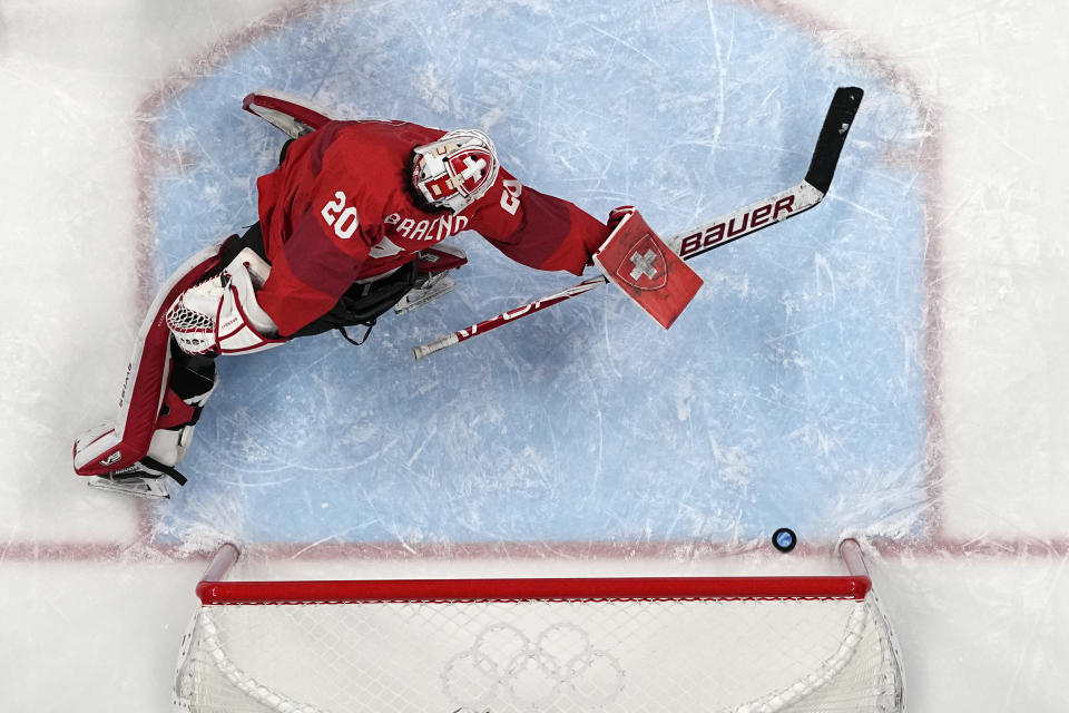 A shot by Canada's Blayre Turnbull gets past Switzerland goalkeeper Andrea Braendli (20) for a goal during a women's semifinal hockey game at the 2022 Winter Olympics, Monday, Feb. 14, 2022, in Beijing. (AP Photo/Petr David Josek)