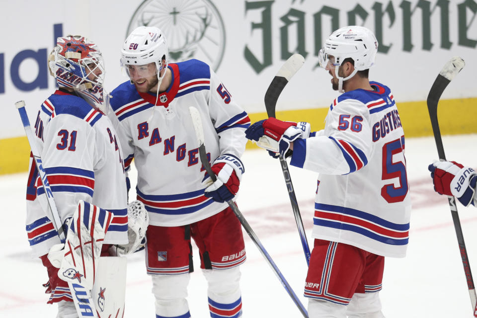 New York Rangers goaltender Igor Shesterkin (31) is joined by left wing Will Cuylle (50) and defenseman Erik Gustafsson (56) after defeating the Washington Capitals in Game 3 of an NHL hockey Stanley Cup first-round playoff series, Friday, April 26, 2024, in Washington. (AP Photo/Tom Brenner)