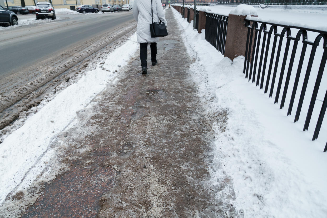 Salt grains, used for melting ice and snow, seen on an icy sidewalk. (Getty Images)