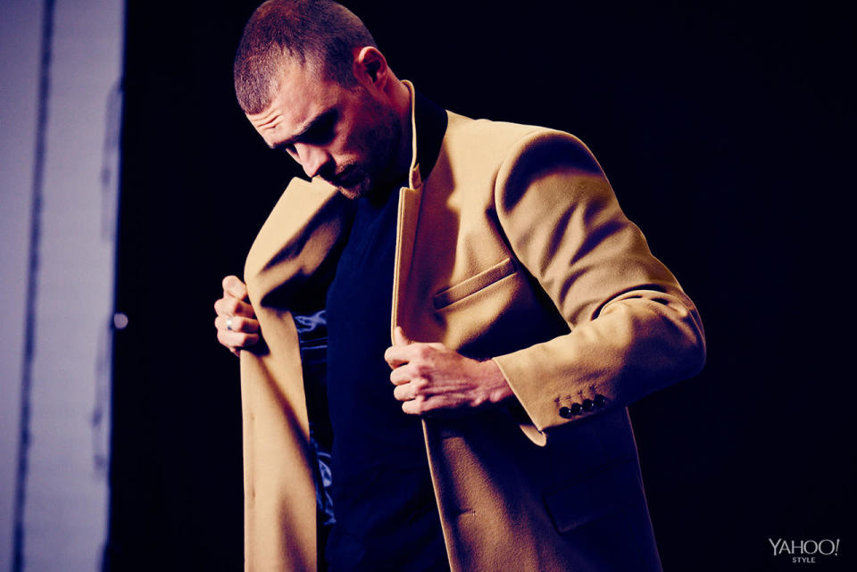 Ed Skrein in a camel colored wool Sandro coat.