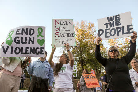 FILE PHOTO: Mourners hold signs during a solidarity vigil in memory of victims of Las Vegas' Route 91 Harvest music festival mass killing, in Newtown, Connecticut U.S., the site of the 2012 Sandy Hook school shooting, October 4, 2017. REUTERS/Michelle McLoughlin/File Photo